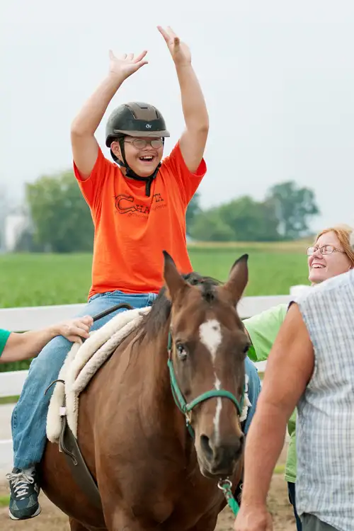 A child benefits from time spent on horseback.